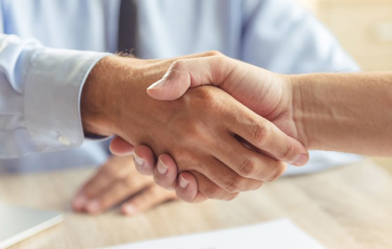 Zwei Personen geben sich die Hand